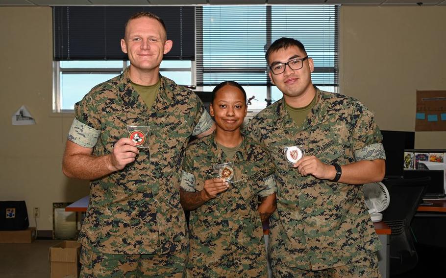Lance Cpl. Joshua Link, left, Cpl. Sigourney Hislop, center, and Lance Cpl. Quinn Van, all finance technicians with Regional Disbursing Office-Pacific, Combat Logistics Regiment, 3rd Marine Logistics Group, pose for a photo after being presented with coins at Camp Foster, Okinawa, Japan.